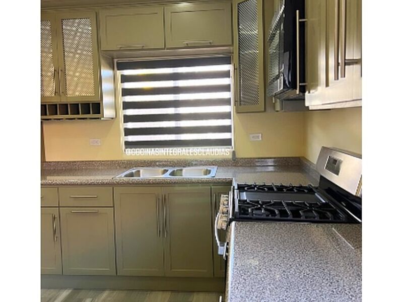 Mesón granito con muebles verde cocina