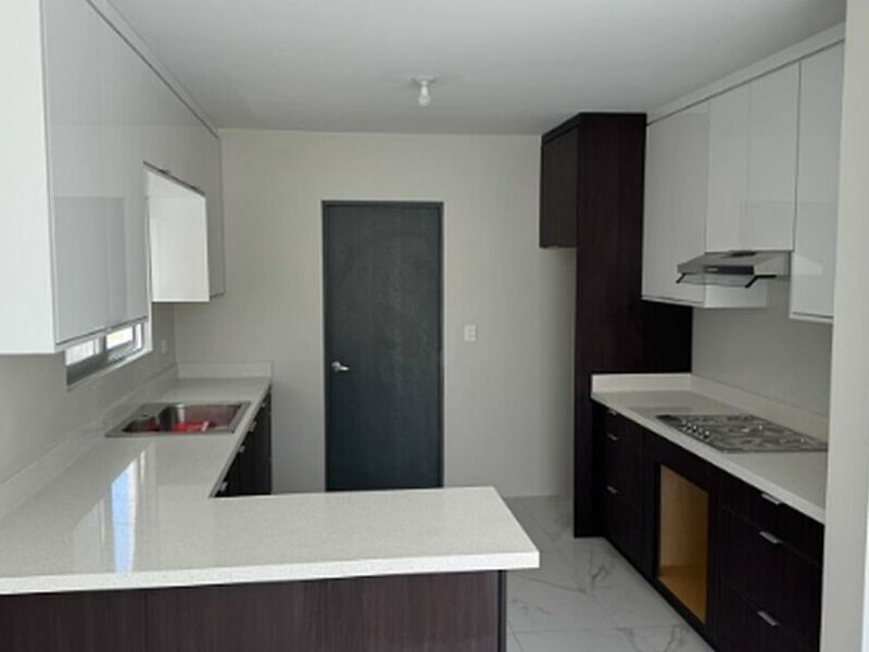 Cocina muebles negros mesón blanco