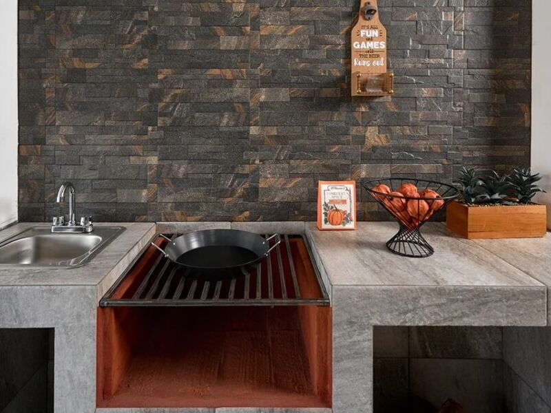 Una cocina con piso de baldosas y lavavajillas negro.