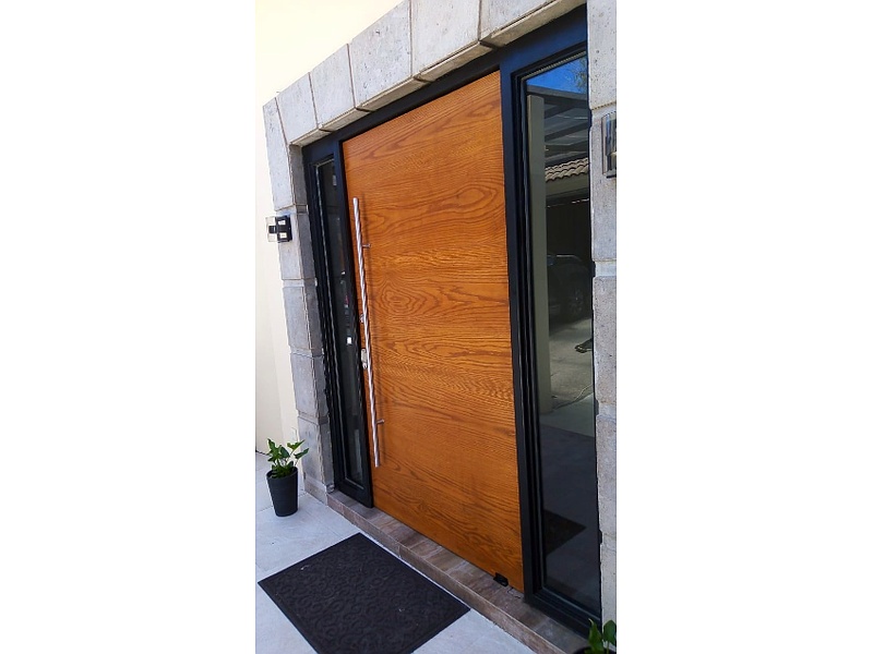 Puerta de encino con marco de herrería y laterales con cristal