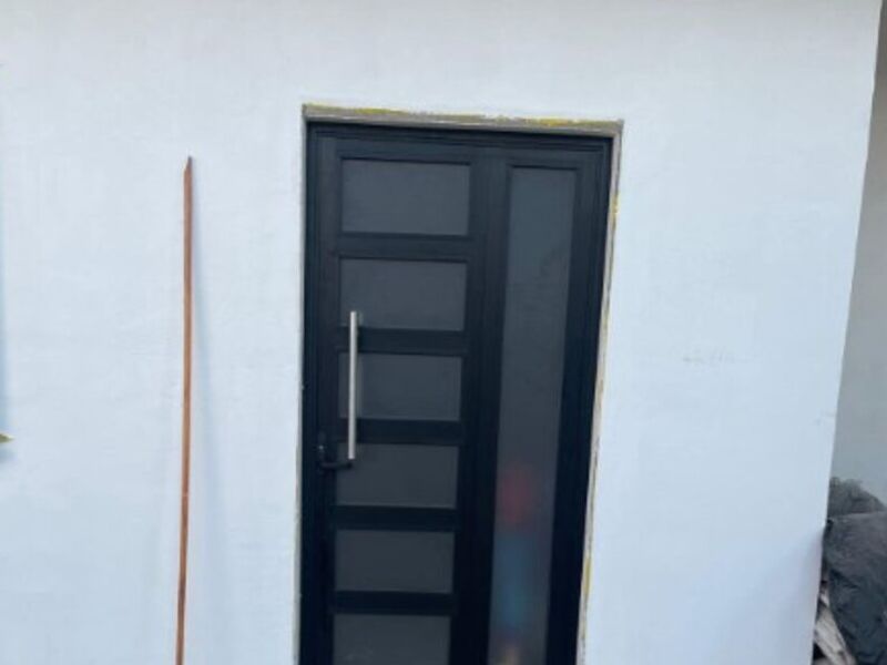 Puerta de aluminio  y vidrio lineal en Merida