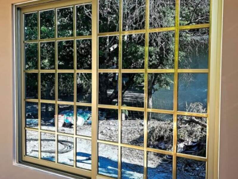 Ventana corrediza cuadriculada dorada México